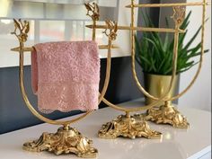 two gold candlesticks with pink towels on them