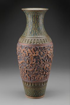 an ornate vase is shown on a gray background