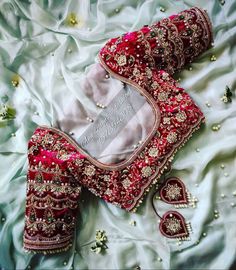 a red and white bridal outfit laying on top of a bed