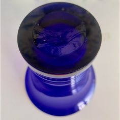 a blue glass object sitting on top of a white table