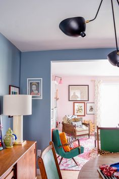 a living room filled with furniture and a lamp hanging over the top of a table