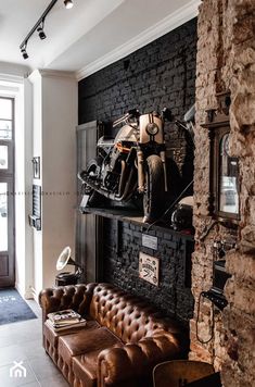 a living room filled with furniture and a motorcycle mounted to the side of a wall