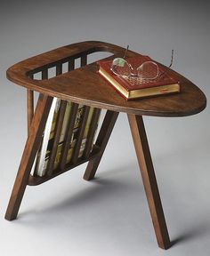 a small wooden table with a book on it and a magazine rack in the middle