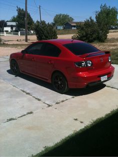 a red car is parked in the driveway