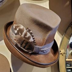 a hat is sitting on top of a table with other hats in the back ground