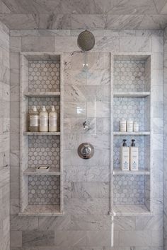 a bathroom with white marble walls and shelves