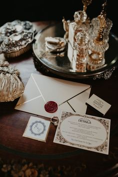 a table topped with lots of different items on top of a wooden table next to a silver tray