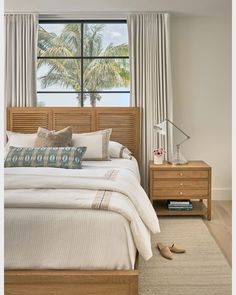 a bedroom with a bed, dresser and window in front of the beach side view