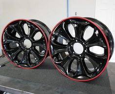 two black and red rims sitting on top of a table