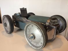 an old toy car made out of metal wheels