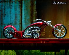 a red motorcycle sitting on top of a wooden table