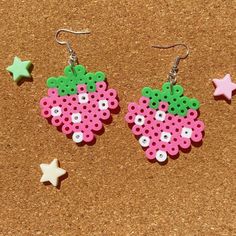 two pairs of pink and green perlery earrings with white dots on them next to stars