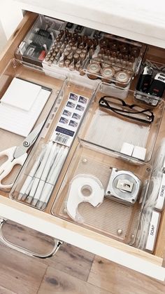 the drawers are organized with various items such as tape, scissors and other office supplies