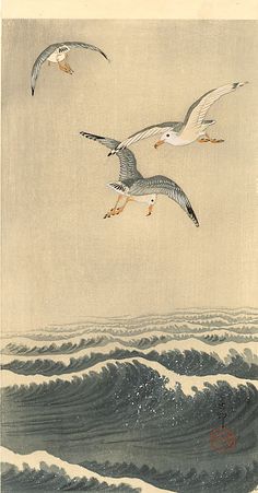 two seagulls are flying over the ocean waves