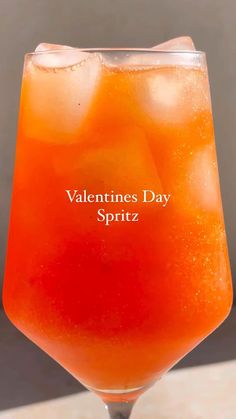 a drink in a glass with the words valentine's day spritz on it