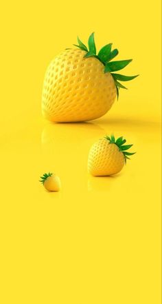 three pineapples sitting on top of a yellow surface