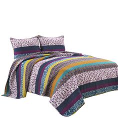 a bed with colorful bedspread and pillows on top of it, in front of a white background