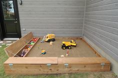 an outdoor sandbox with toys in it
