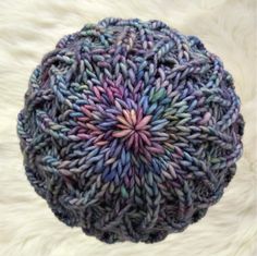 a knitted ball sitting on top of a fur covered floor