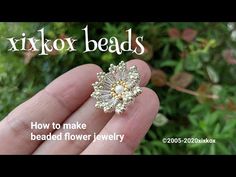 a person holding a flower shaped brooch in their hand with the words fixox beads on it