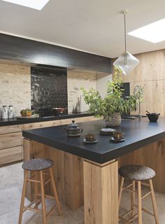 a kitchen island with two stools and a potted plant on top of it