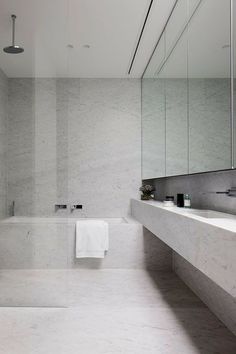 a white bathroom with marble walls and floor