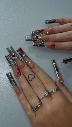 Santa Fe Klan Nails, Gothic Baddie Nails, French Tip Acrylic Nails With Charms, Silver And Red Prom Nails, Paeka Degallo Acrylic Nails, Bratz Acrylic Nails, Nails With Charms Black, Rockstar Nails Acrylic, Cholo Nails