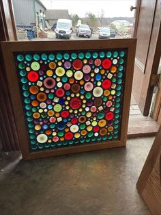 an art piece made out of glass with circles and dots on the bottom, sitting in front of a door