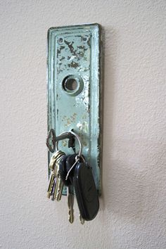 a bunch of keys that are on a doorknob attached to a wall with a key chain