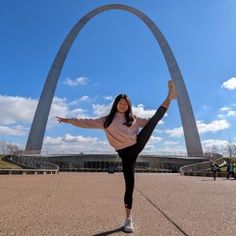 a woman is doing yoga in front of the st louis arch