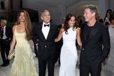 three men and two women in tuxedos standing next to each other at an event