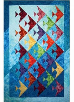 a colorful quilt with many different colored fish on the front and bottom, along with blue background