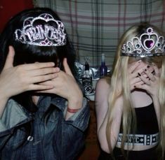 two girls with tiaras covering their faces