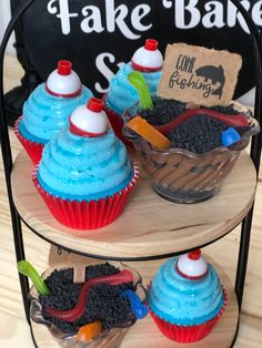 two tiered trays holding cupcakes with blue frosting