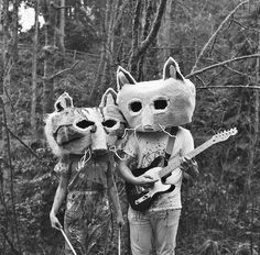 two people wearing animal masks and holding guitars