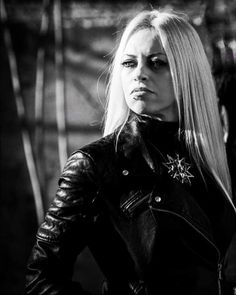 a woman with long blonde hair wearing a leather jacket