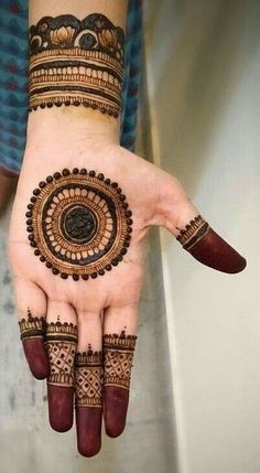 a woman's hand with hennap on it and an intricate design in the middle