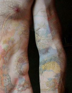 the back of a man with tattoos on his body and arms, all covered in colored ink