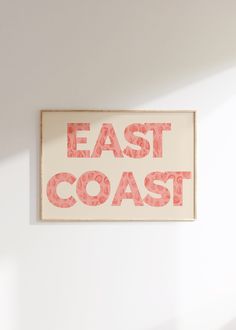a sign that says east coast hanging on the wall in a room with white walls