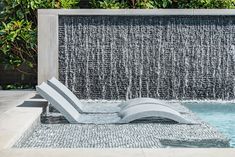 a water fountain with a lounge chair in front of it