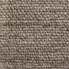 an up close shot of the texture of a rug with small squares on it, in grey tones