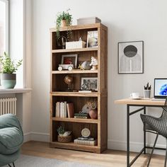 a room with a chair, desk and bookshelf in front of a window