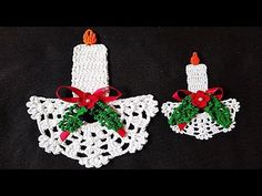 two crocheted christmas stockings with candles on them, one is white and the other is red