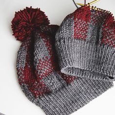 a knitted hat and scarf laying on top of a white table next to scissors