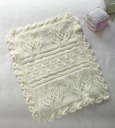 two crocheted items are laying on a white bed sheet next to each other