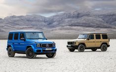 two vehicles parked in the desert with mountains in the background