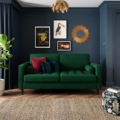 a living room with dark blue walls and green couches in the corner, along with pictures on the wall