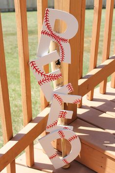 the baseball is hanging on the wooden railing