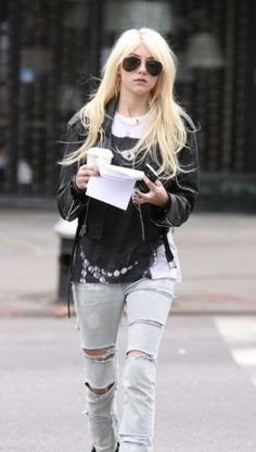 a woman walking down the street with ripped jeans