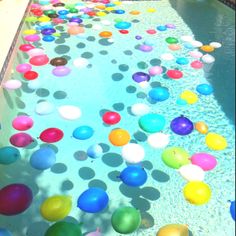 colorful balloons floating in the water at a pool